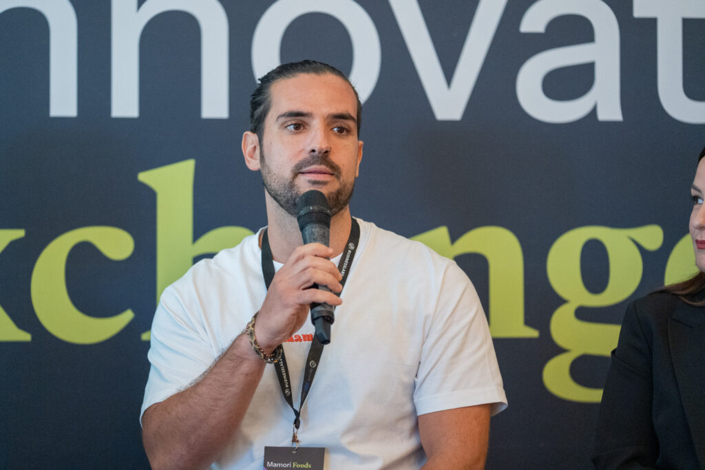 A panellist speaking in front of The Innovation Exchange lettering.