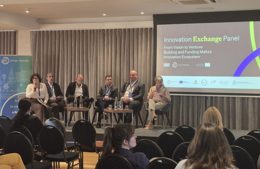 The full panel on stage at Salini Resort, beside the EIT Urban Mobility banner.